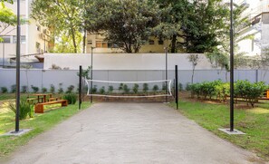 A volleyball court with a net, surrounded by greenery and benches. - Beautiful Studio 110m, Oscar Freire Street Rao1520 (São Paulo)