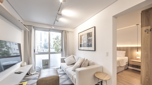 A modern, well-lit living room with a sofa, a small table, and a TV. - Functional Apartment in Itaim Bibi SP - Sat0012 (São Paulo)
