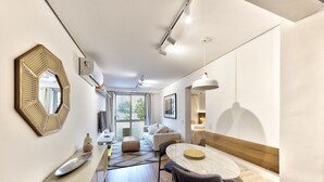 A modern, well-lit hotel room with a large mirror, a round dining table, and a cozy seating area. - Functional Apartment in Itaim Bibi SP - Sat0012 (São Paulo)
