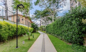 A pathway lined with greenery, a lamp post, and a no-entry sign.