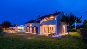 A modern two-story house with a swimming pool, a well-maintained lawn, and a large tree in the background. - Luxurious home in Porec (Porec)