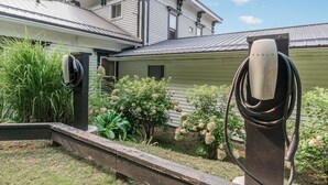 A house with a Tesla electric vehicle charging station in the front yard. - Gold Room at Newaygo Bed & Breakfast (Newaygo)