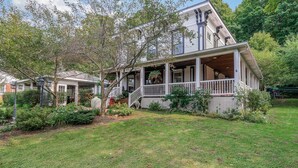 A two-story house with a porch, surrounded by a well-maintained garden and trees. - The Shore Line Room at Newaygo Bed & Breakfast (Newaygo)