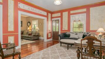 A spacious living room with a fireplace, a sofa set, and a wooden chair.