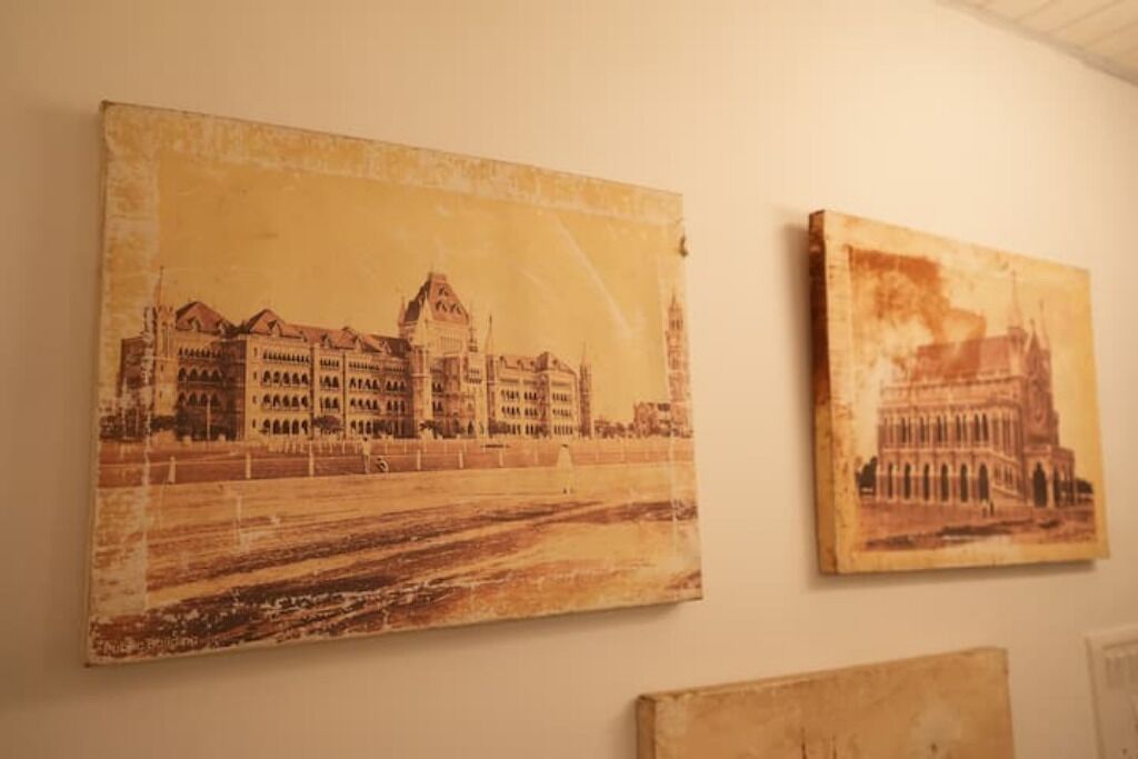 Two paintings of buildings on a wall.