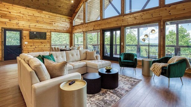 A spacious living room with a large sectional sofa, a green armchair, and a coffee table.