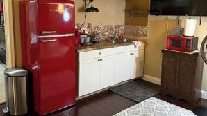 A compact kitchen with a red refrigerator, white cabinets, a microwave, and a television above the counter. - Gated community 2-bedroom,1 bath attached apartment in Manteca (Manteca)