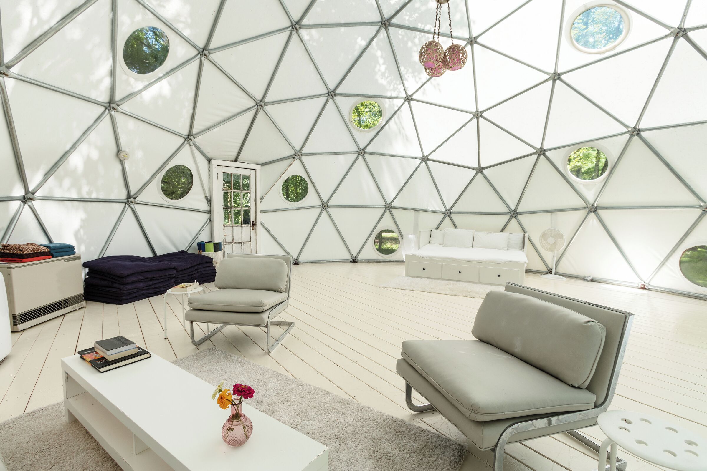 A modern, geometric-patterned room with a white sofa, a white coffee table, and a small white side table.