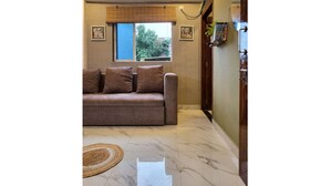 Una sala de estar con un sofá, una ventana y una puerta.
