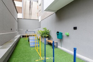 A children's play area with artificial turf, play structures, and potted plants. - Beautiful and Functional Apartments in Curitiba - WSH (Curitiba)