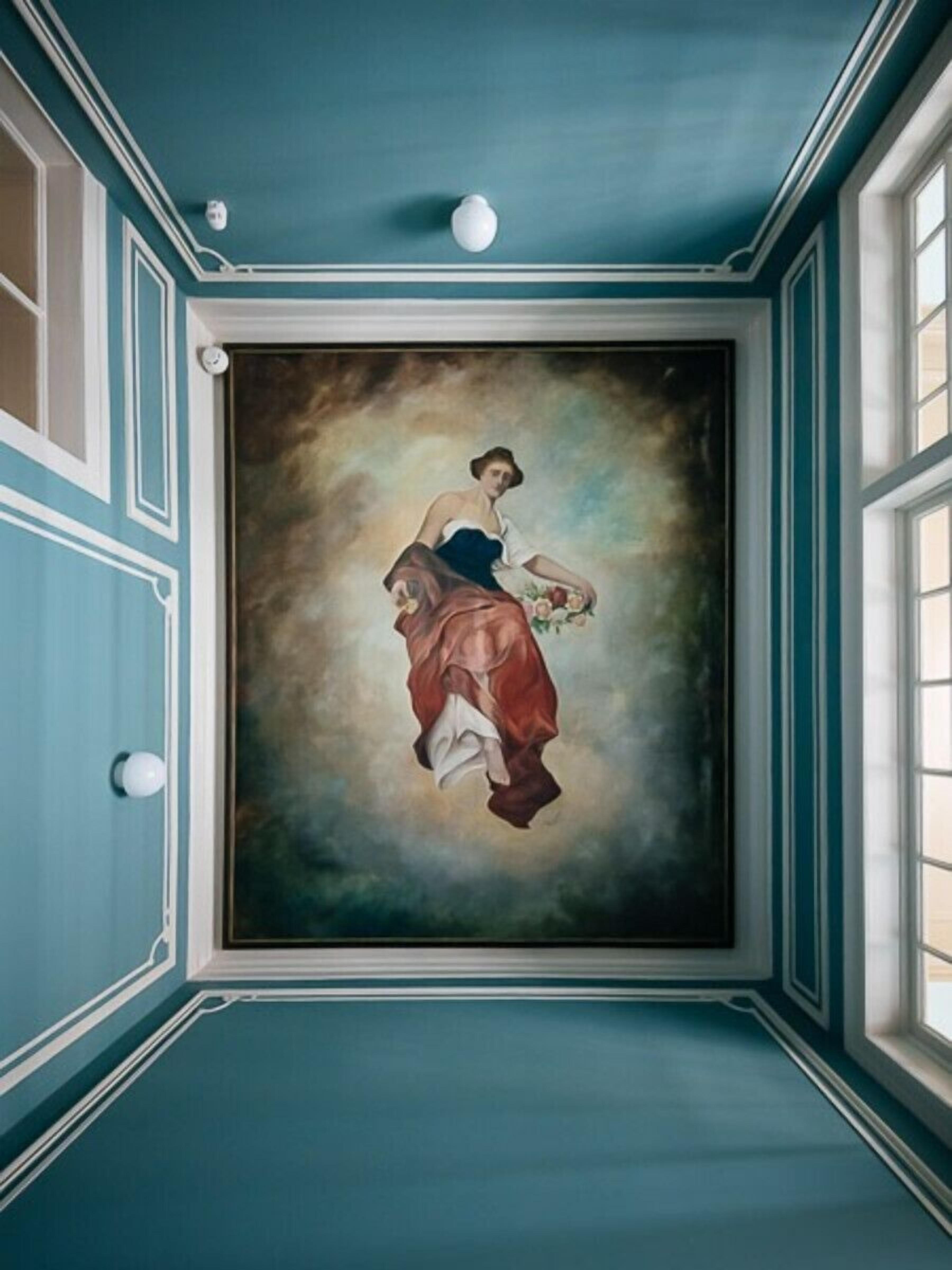 Ein Zimmer mit einem großen Gemälde an der Wand, einem Fenster und einer blauen Decke.