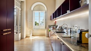 A modern kitchen with wooden flooring, a built-in oven, a sink, and a countertop with various appliances. - PG - 1D - T2 Superior - Palacete do Guadiana (Vila Real Santo Antonio)