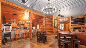 A log cabin interior with a kitchen, dining area, and living room.