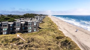 Ein Küstenhotel mit mehreren Gebäuden, einem Sandstrand und dem Meer im Hintergrund.