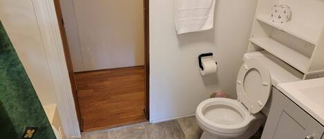 Une salle de bain équipée de toilettes, d’un porte-serviettes et d’un support à papier toilette.