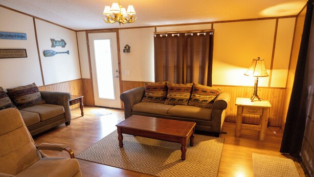 A cozy living room with two sofas, a coffee table, a lamp, and a rug. - Remodeled Cottage 4 at the King Creek Lodge and Marina (Benton)