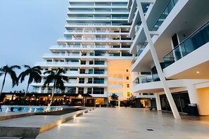A modern multi-story hotel with a pool area, featuring a spacious outdoor terrace and multiple balconies. - SONESTA (Cartagena)