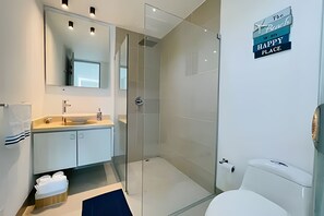 A modern bathroom with a glass shower enclosure, a white sink, and a toilet. - SONESTA (Cartagena)