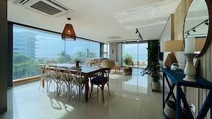 A spacious room with a large dining table, chairs, and a view of the city. - SONESTA (Cartagena)