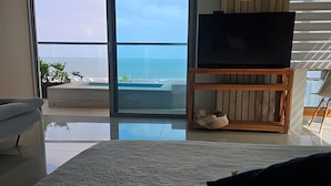 A modern living room with a large glass door leading to a balcony overlooking the sea. - SONESTA (Cartagena)