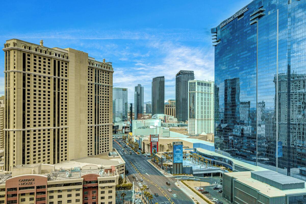 A cityscape with modern high-rise buildings, including a hotel with a prominent glass facade.