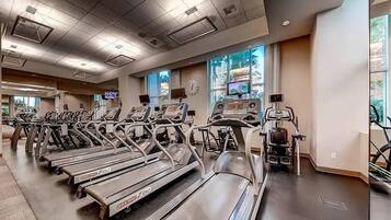 A gym with treadmills, stationary bikes, and elliptical machines.