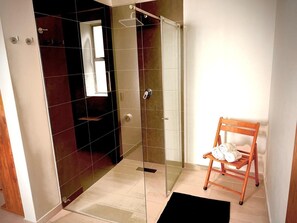 Een douche, handdoeken, zeep, toiletpapier
