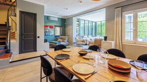 A dining area with a wooden table set for four, surrounded by chairs. - Villa du Val - Welkeys (Aix-en-Provence)