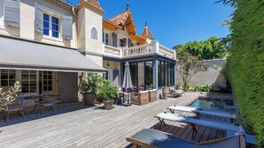 A wooden deck with lounge chairs, a pool, and outdoor furniture. - Villa du Val - Welkeys (Aix-en-Provence)