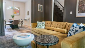 A living room with a sofa, coffee table, and a staircase.