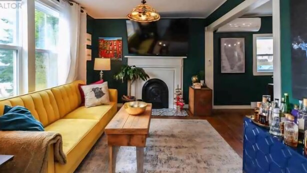 A cozy living room with a yellow sofa, a wooden coffee table, and a fireplace.