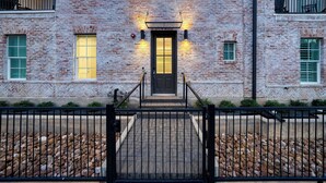 A brick building with a black door and a small set of stairs leading to the entrance. - Town Lake Townhouse by Avantstay Hot Tub, Game Room & Skyline Views (Austin)