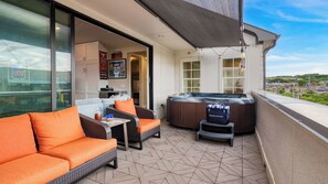 Un balcon avec mobilier d’extérieur, un jacuzzi et une vue sur la ville.