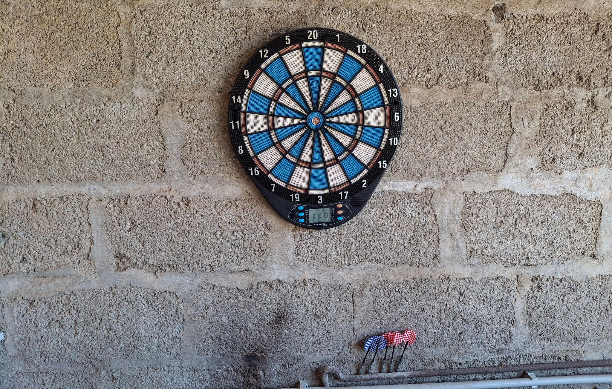 A dartboard mounted on a textured wall.