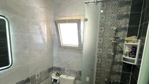 Een badkamer met toilet, wastafel en douche.