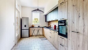 Eine moderne Küche mit Backofen, Kühlschrank und einem Fenster für natürliches Licht.