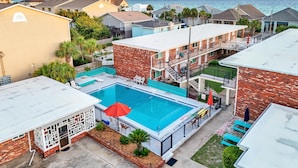 Un barrio residencial con piscina, edificios de ladrillo y vistas al océano.