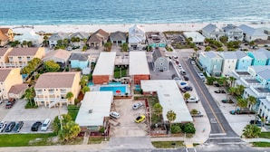 Zona residencial costera con casas, una playa y un estacionamiento.