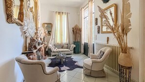 Ein Wohnzimmer mit einer Couch, zwei Sesseln, einem Couchtisch und Dekorationselementen.