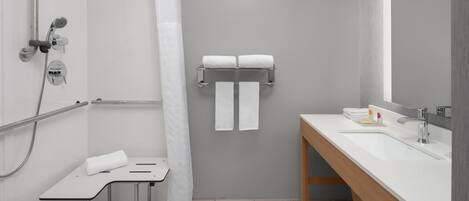 Un baño moderno con ducha, lavabo y toallero.