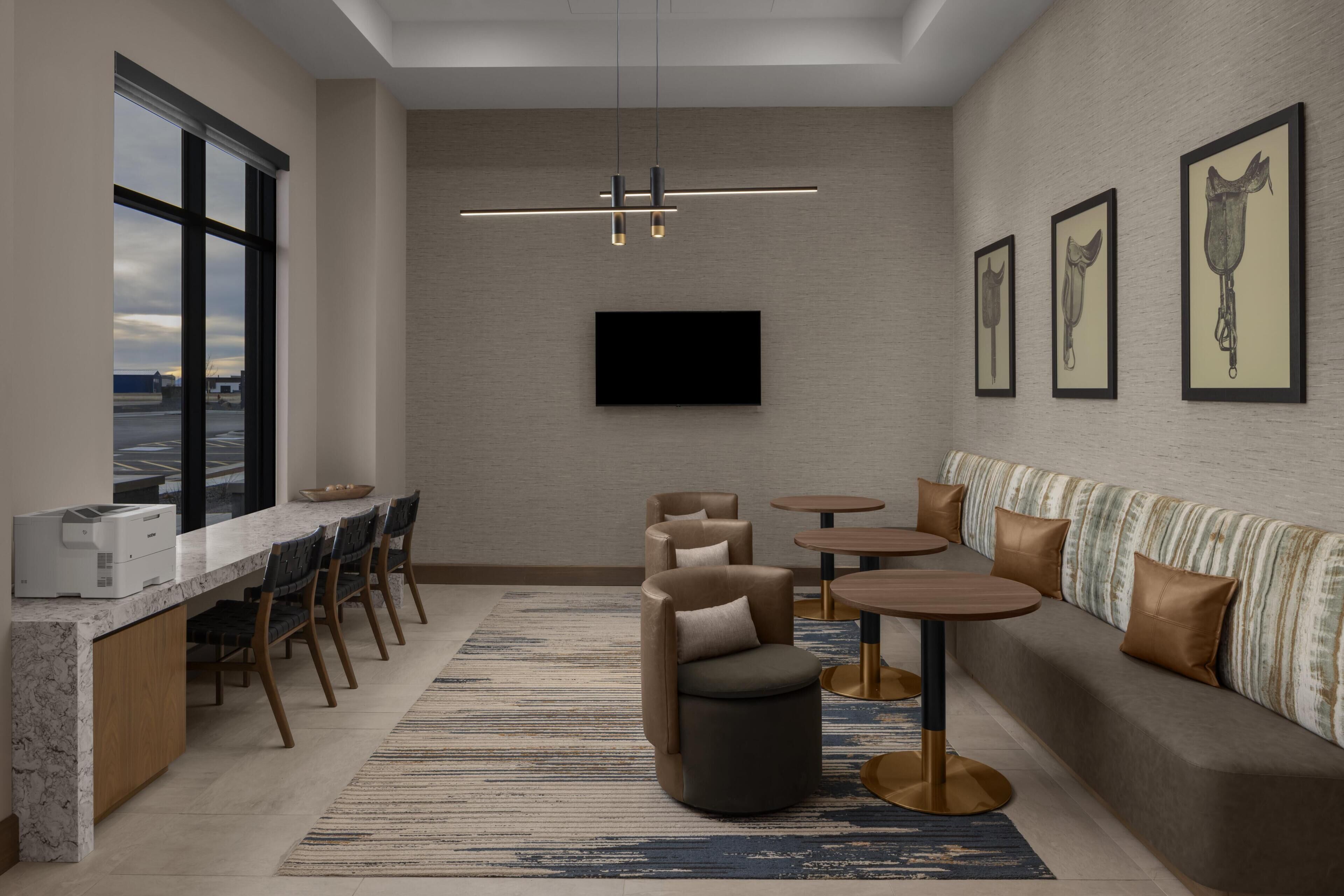 A modern interior with a bar area, seating, a flat-screen TV, and artwork on the walls.