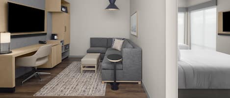 Ein modernes Hotelzimmer mit Sofa, Schreibtisch und Bett.