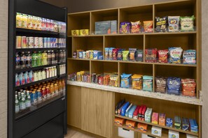 A self-service beverage and snack station with various drinks, snacks, and condiments.