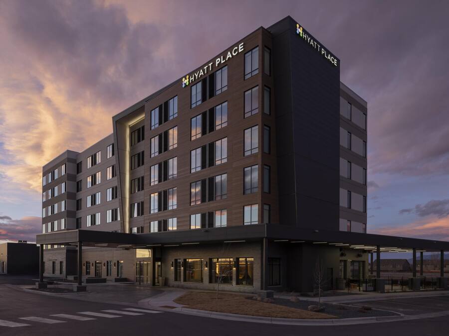 Un hôtel à plusieurs étages au design moderne, avec une grande enseigne « Hyatt Place » bien visible sur le toit.