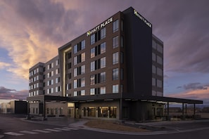 Un hotel de varios pisos con diseño moderno, que presenta un letrero llamativo de 'Hyatt Place' en la parte superior.