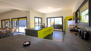 A modern kitchen with a central island, large windows, and a dining area with chairs. - Cozy home in Montboucher sur Jabron (Montboucher sur Jabron)