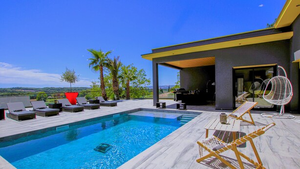 A modern outdoor pool area with lounge chairs, a barbecue, and a view of the landscape. - Cozy home in Montboucher sur Jabron (Montboucher sur Jabron)