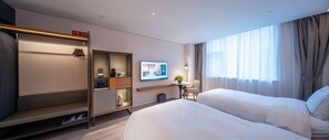 A hotel room with a bed, a desk, a television, and a window with curtains.