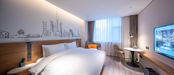 Une chambre d’hôtel avec un grand lit, un bureau avec une chaise, une télévision et un mur orné d’un dessin représentant un paysage urbain.