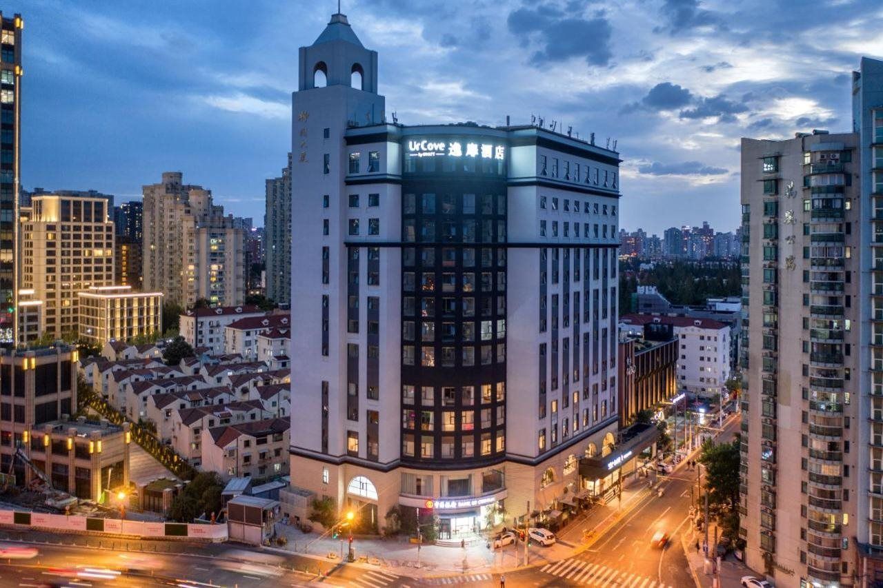 Un hotel de varios pisos con una ubicación destacada en una esquina, que cuenta con una entrada amplia y un letrero de restaurante visible.